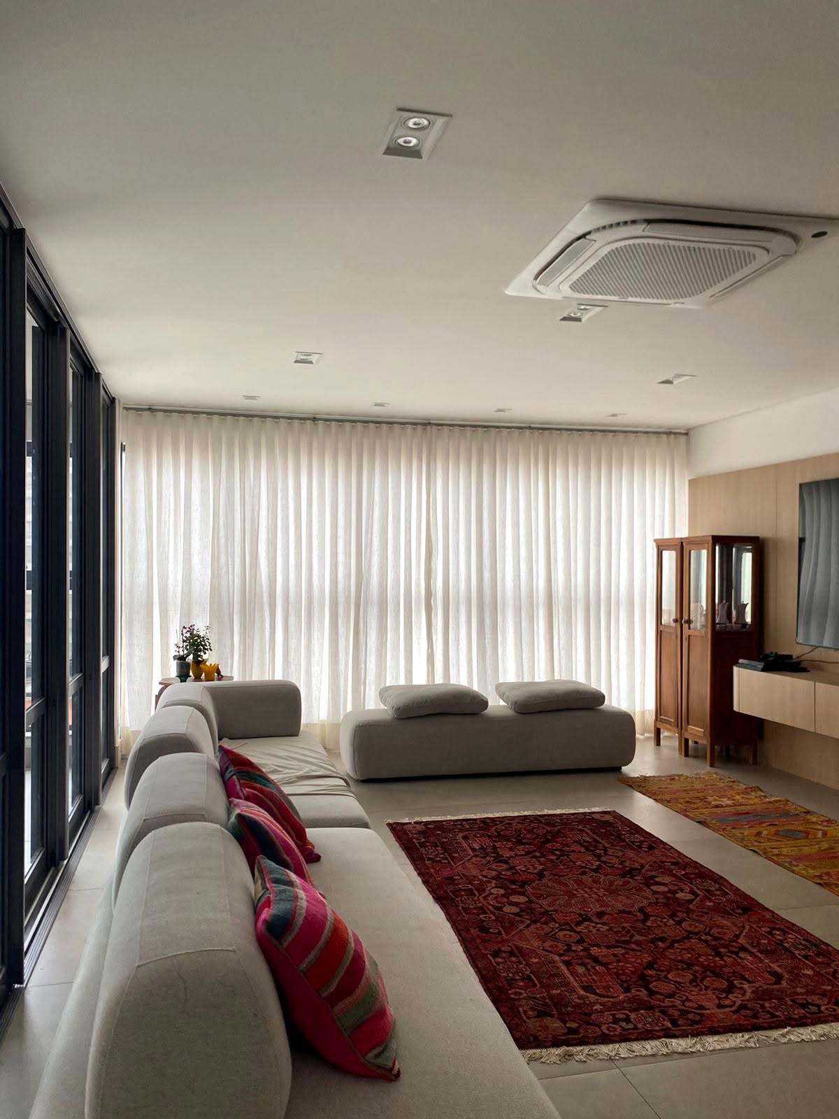 Cortinas claras em uma sala de estar ampla com sofá branco