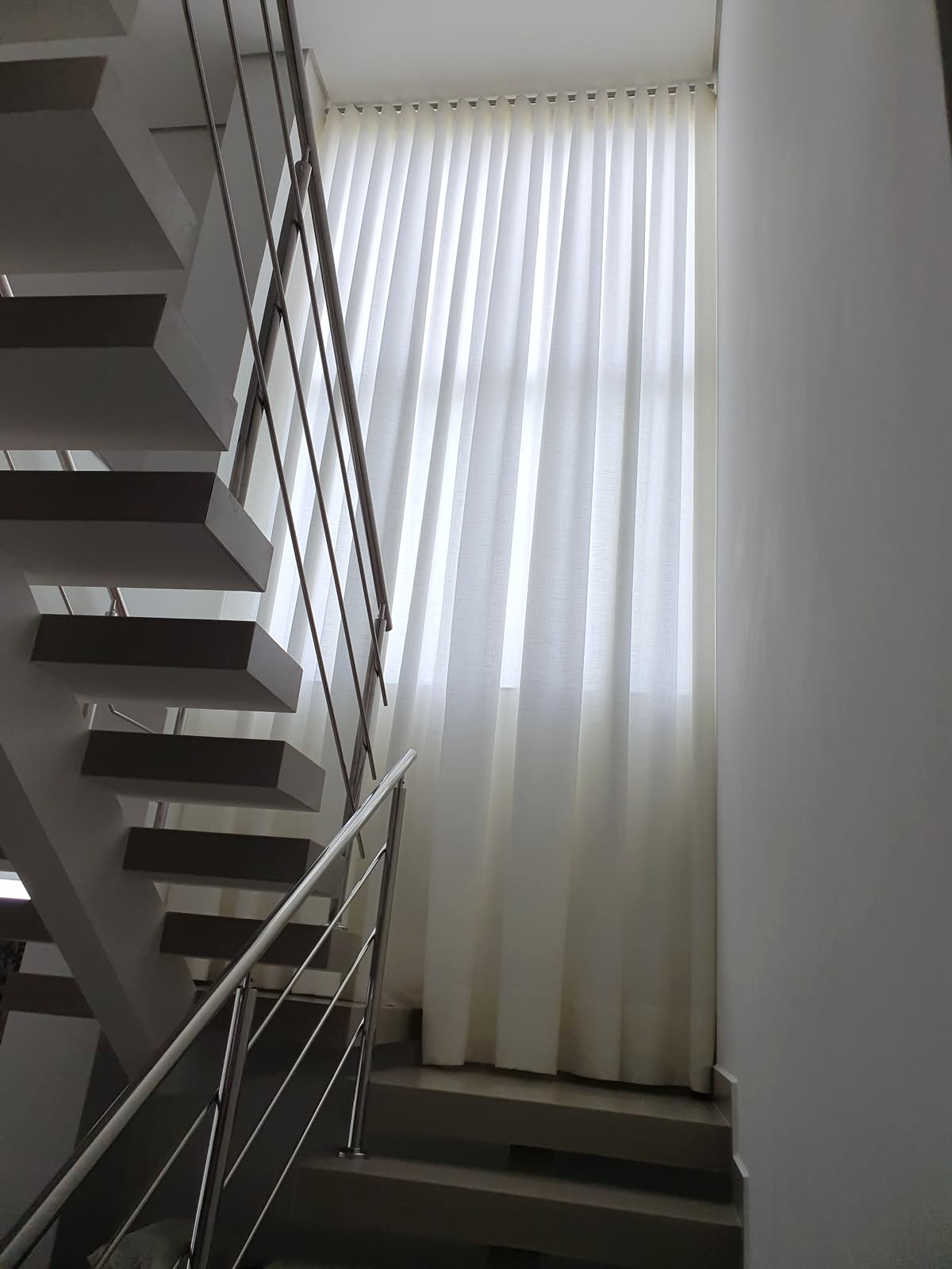 Cortina de pé-direito duplo acompanhando uma escada