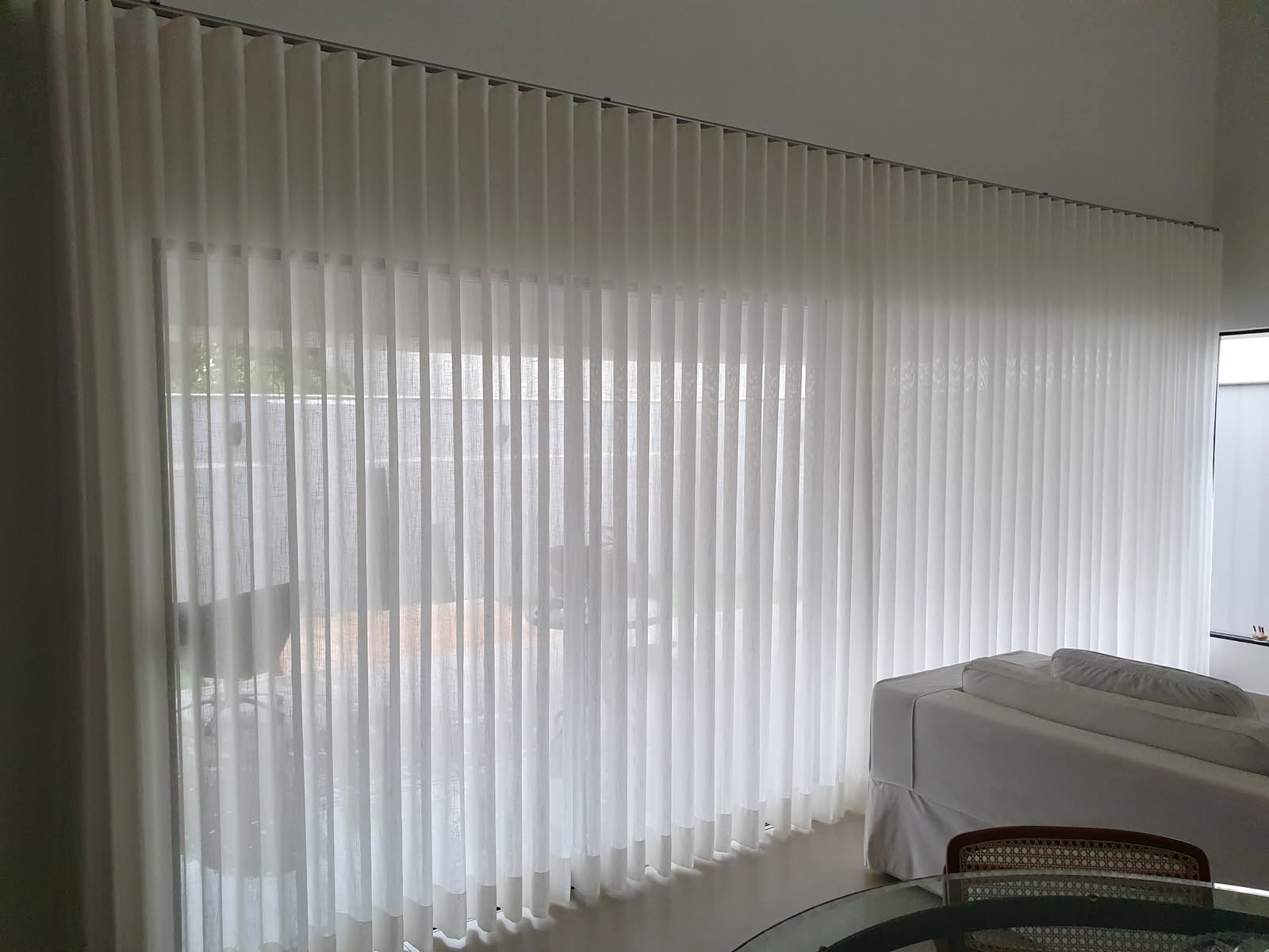 Cortinas brancas filtrando a luz na sala